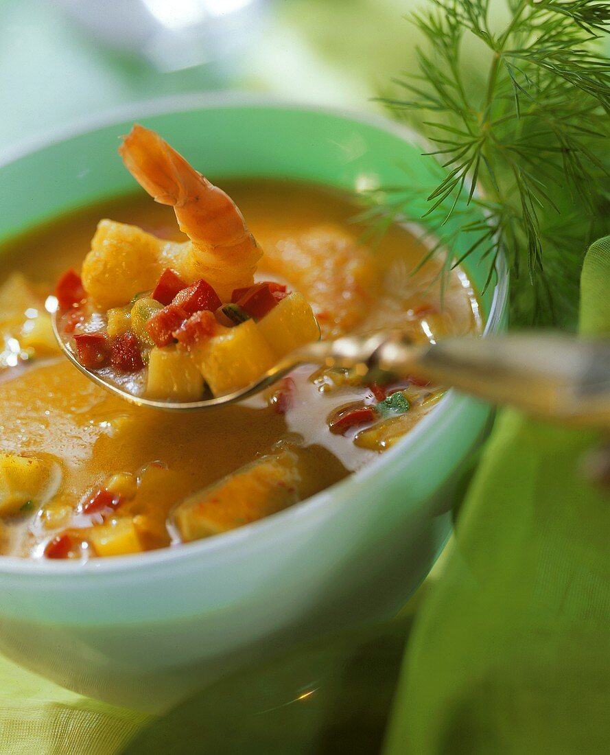Fischsuppe mit Curry im Schälchen und auf Löffel