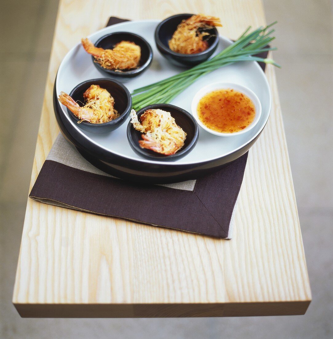 Deep-fried shrimps in rice noodle cases with Asian dip