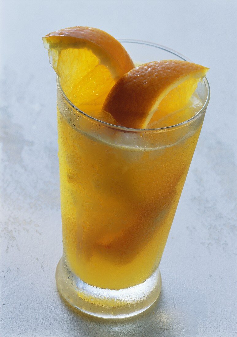 Glass of orange juice with soda, decorated with orange slices