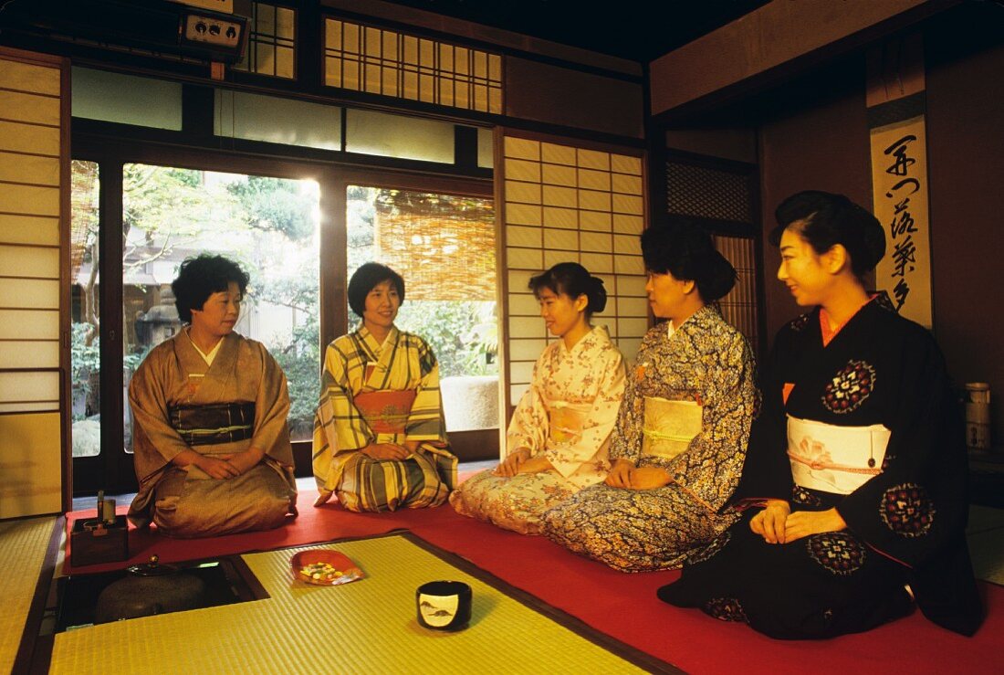 Japanese women kneeling on the floor beginning tea ceremony