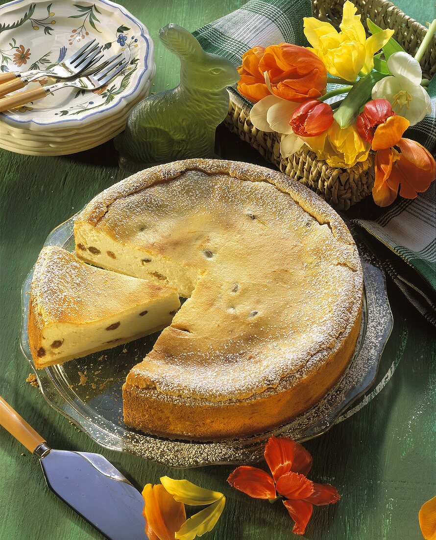 Ein angeschnittener Käsekuchen mit Puderzucker bestreut