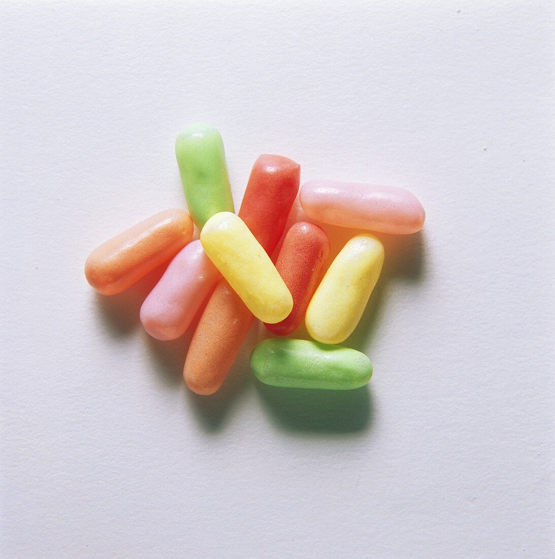 A heap of different-coloured, oblong sweets