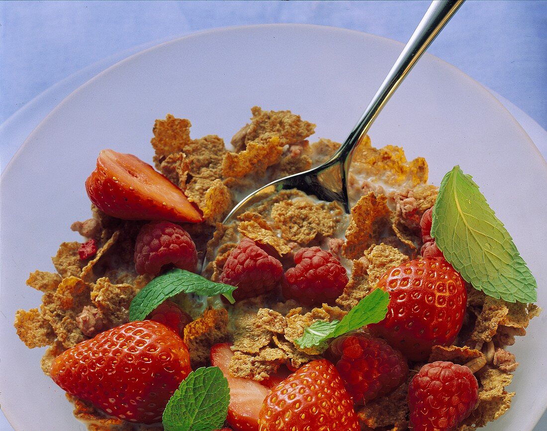 Eine Schüssel mit Vollkorn-Cornflakes, Erdbeeren & Himbeeren