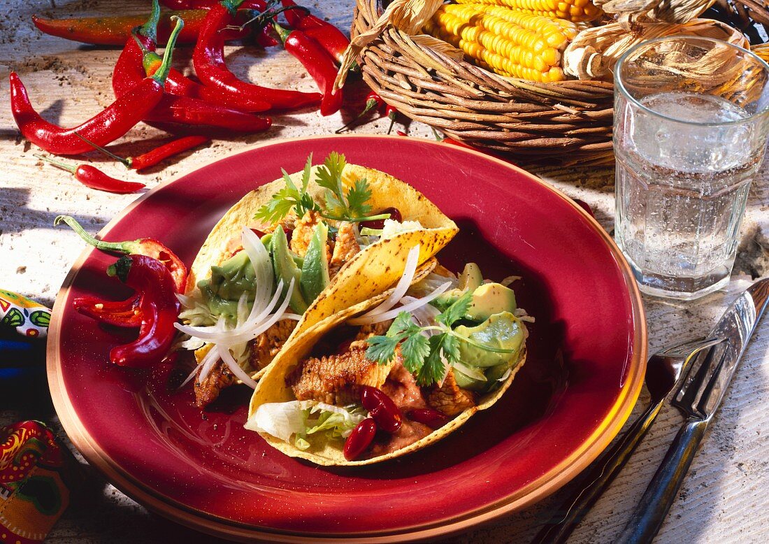 Two tacos with beef, avocados and red beans