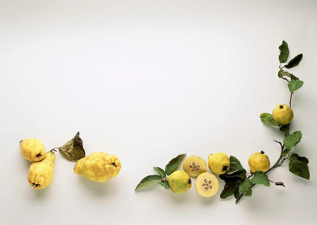 Several quinces (whole and cut fruits)