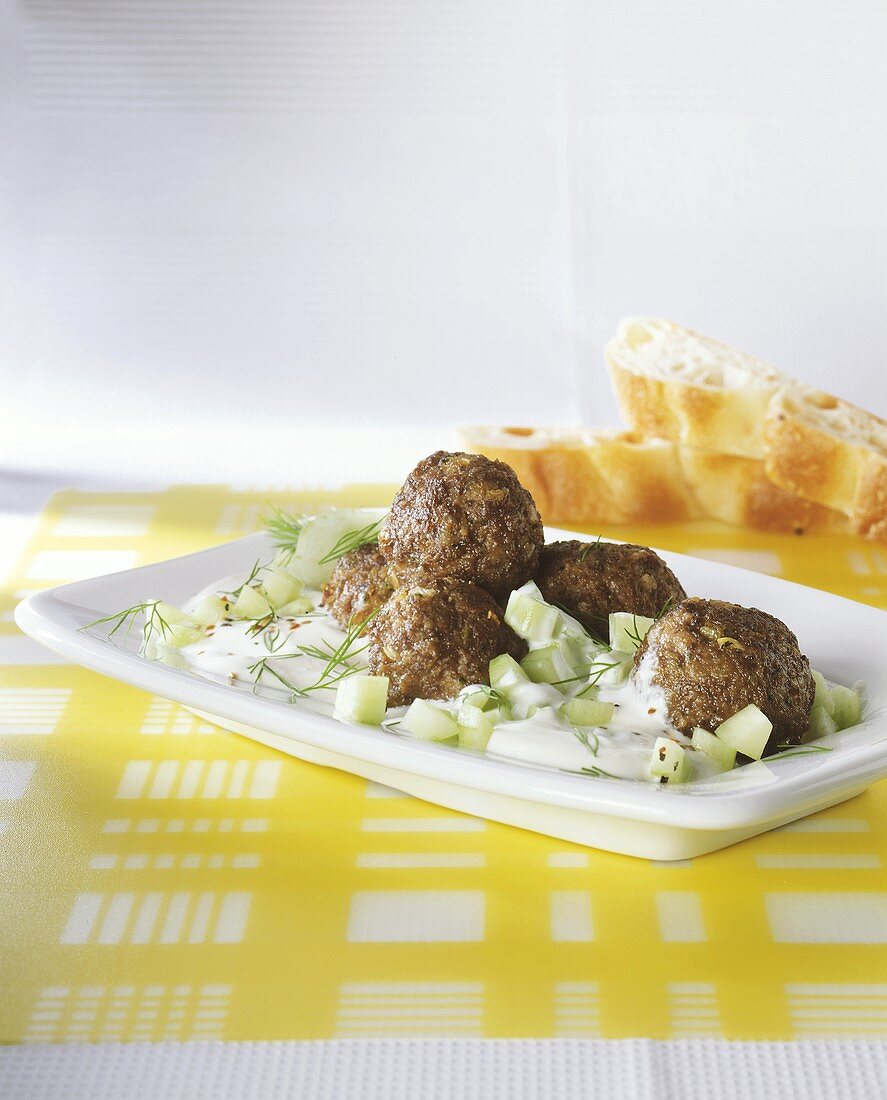 Meatballs with dill & yoghurt sauce and cucumber pieces