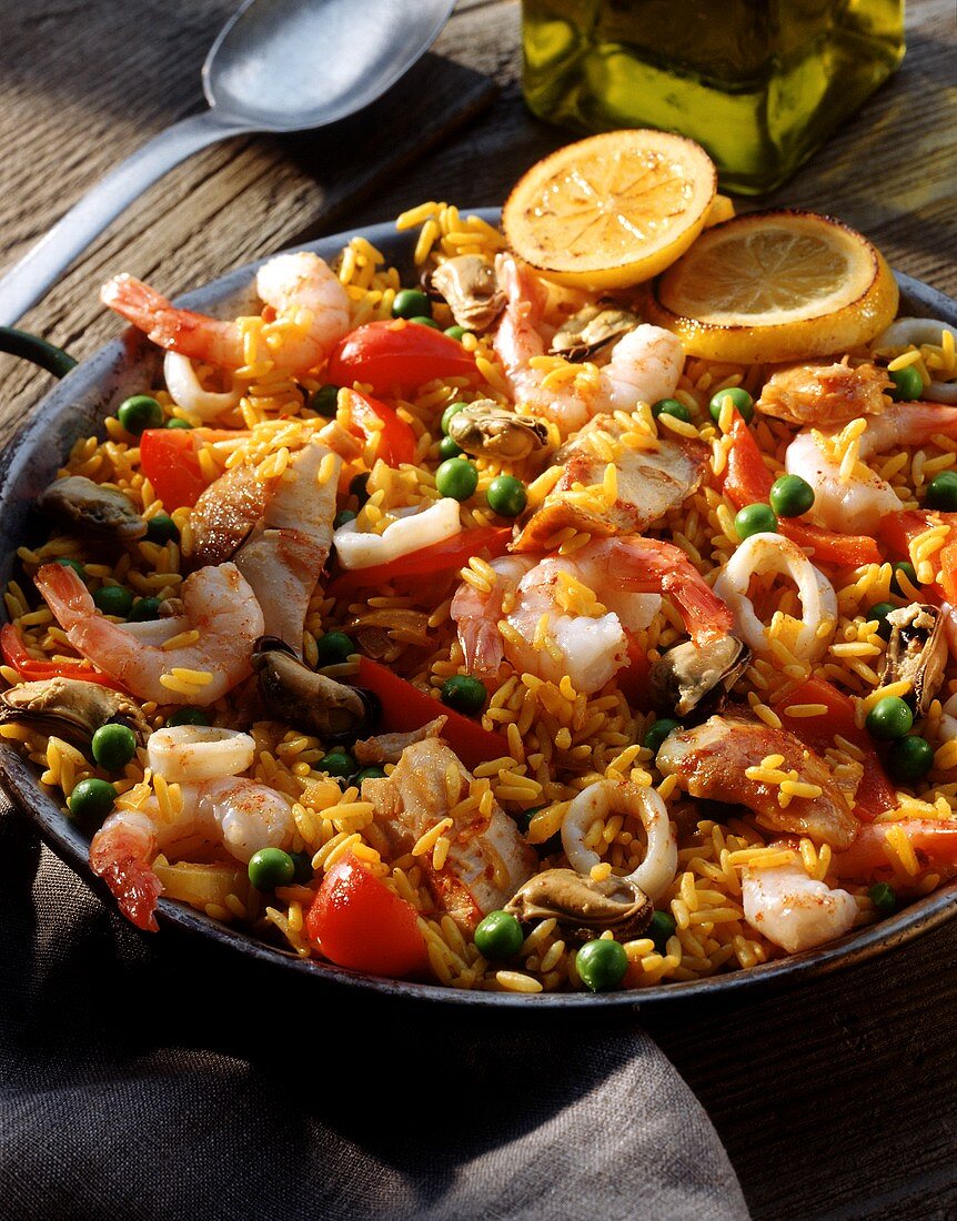 Paella in Paellapfanne auf Holzuntergrund