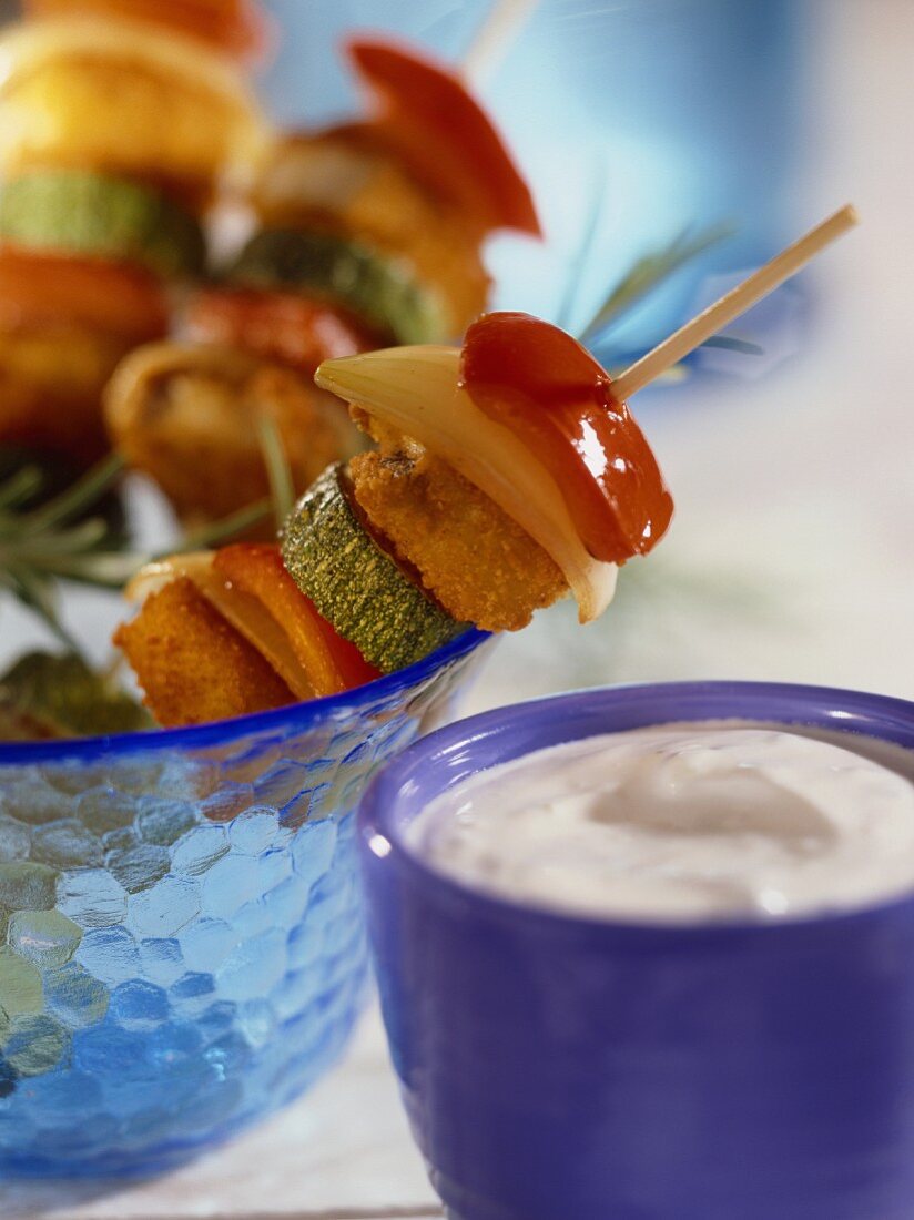 Fish finger and vegetable kebabs and a bowl of tzatziki