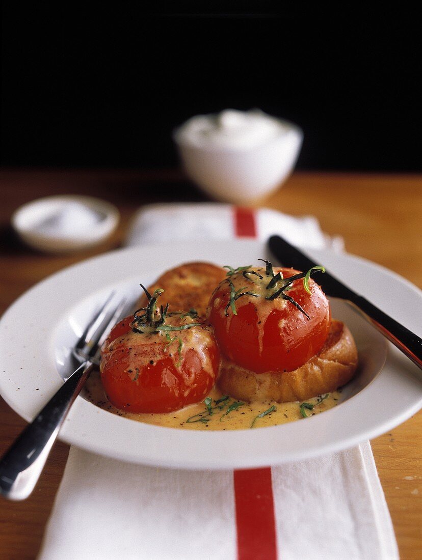 Gebackene Tomaten mit Senfsauce und Brot in tiefem Teller