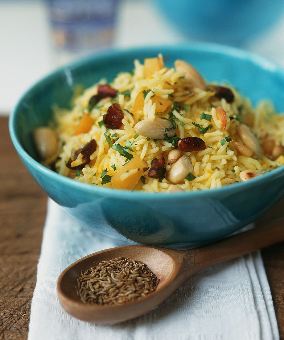 Safran-Paprika-Reis mit Nüssen in einer blauen Schale
