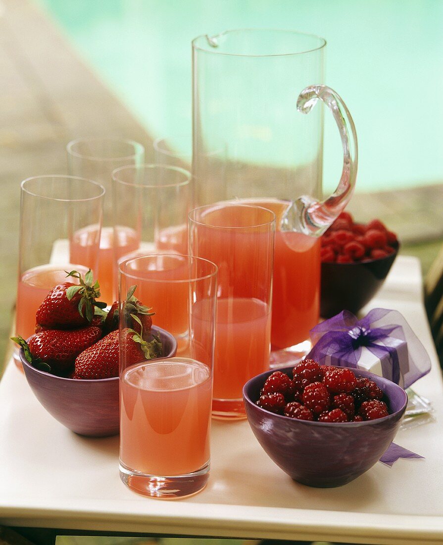 Red berry drink in glasses and a glass jug