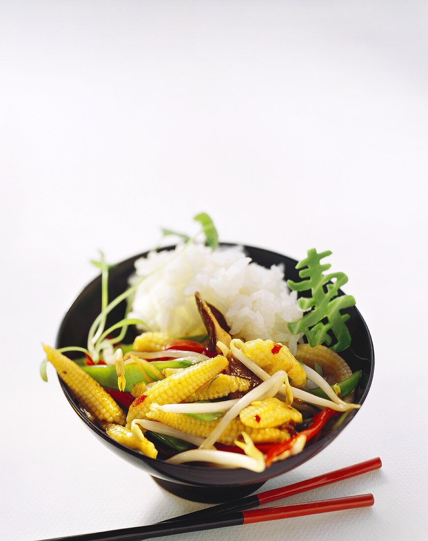 Asiatische Gemüsepfanne mit Reis im Schälchen