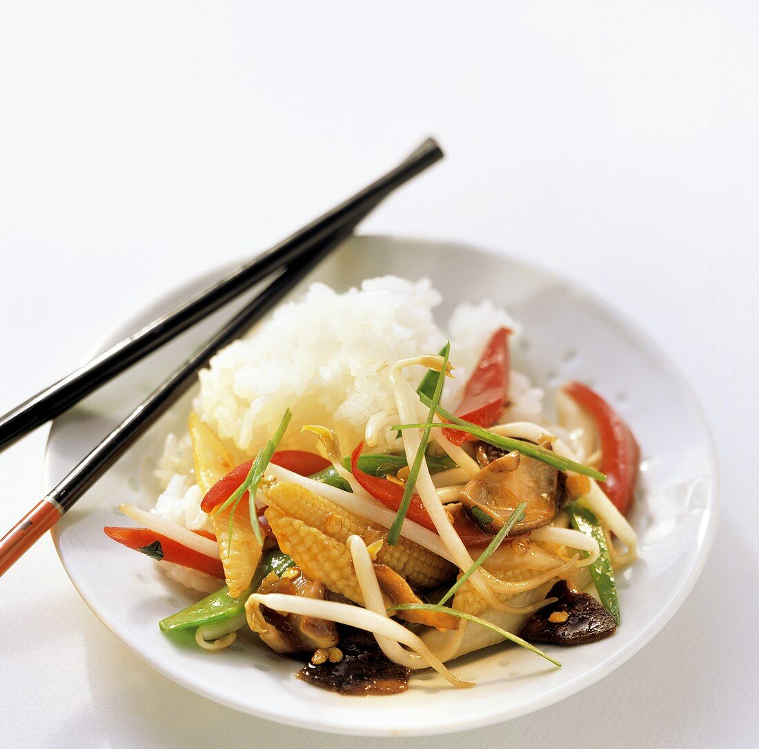 Asian vegetable stir-fry with rice on plate