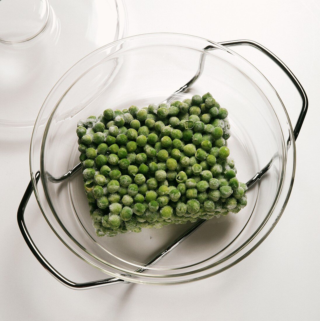 Frozen peas defrosting in a glass dish