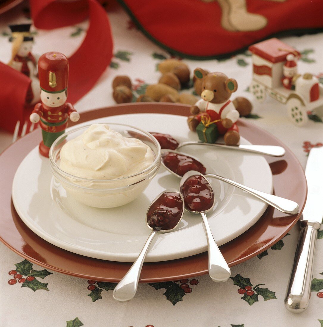 Ein Schälchen Vanillecreme und Löffel mit Roter Grütze