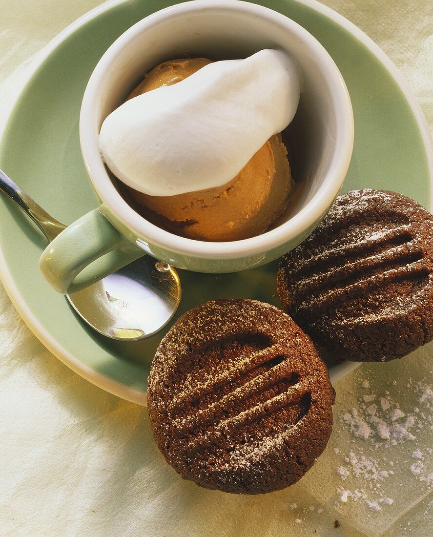 Mocha ice cream with cream in cappuccino cup, biscuits