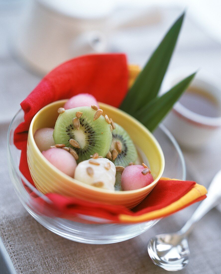 Exotic fruit salad with cream and sunflower seeds