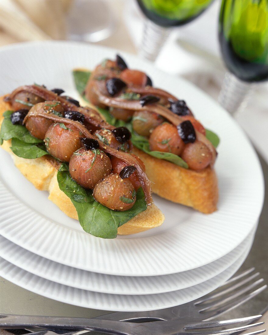 Bruschetta with peeled tomatoes, olives and sardines