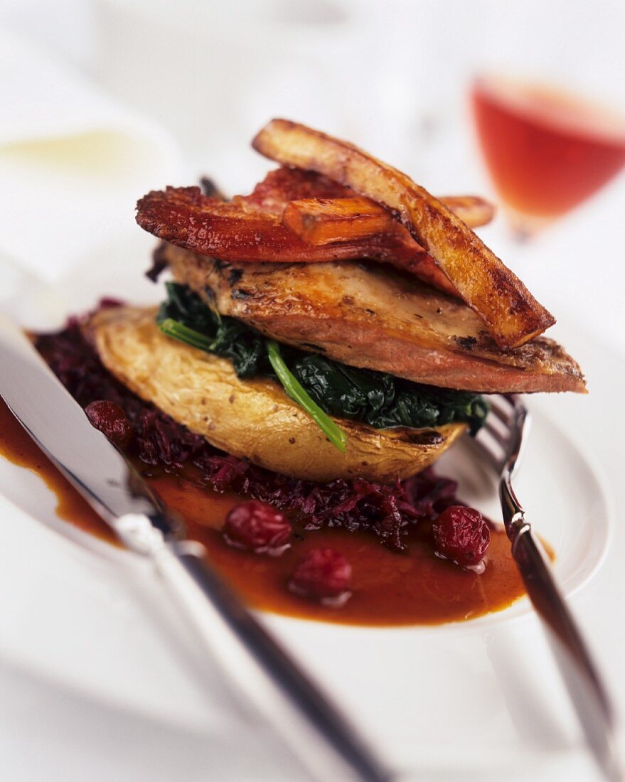 Pheasant on red cabbage, baked vegetables, bacon & cranberries