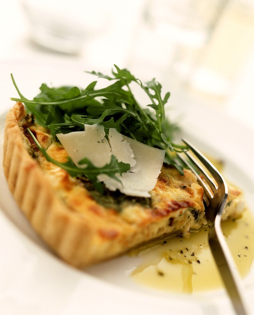 Bacon quiche with rocket and Parmesan on plate