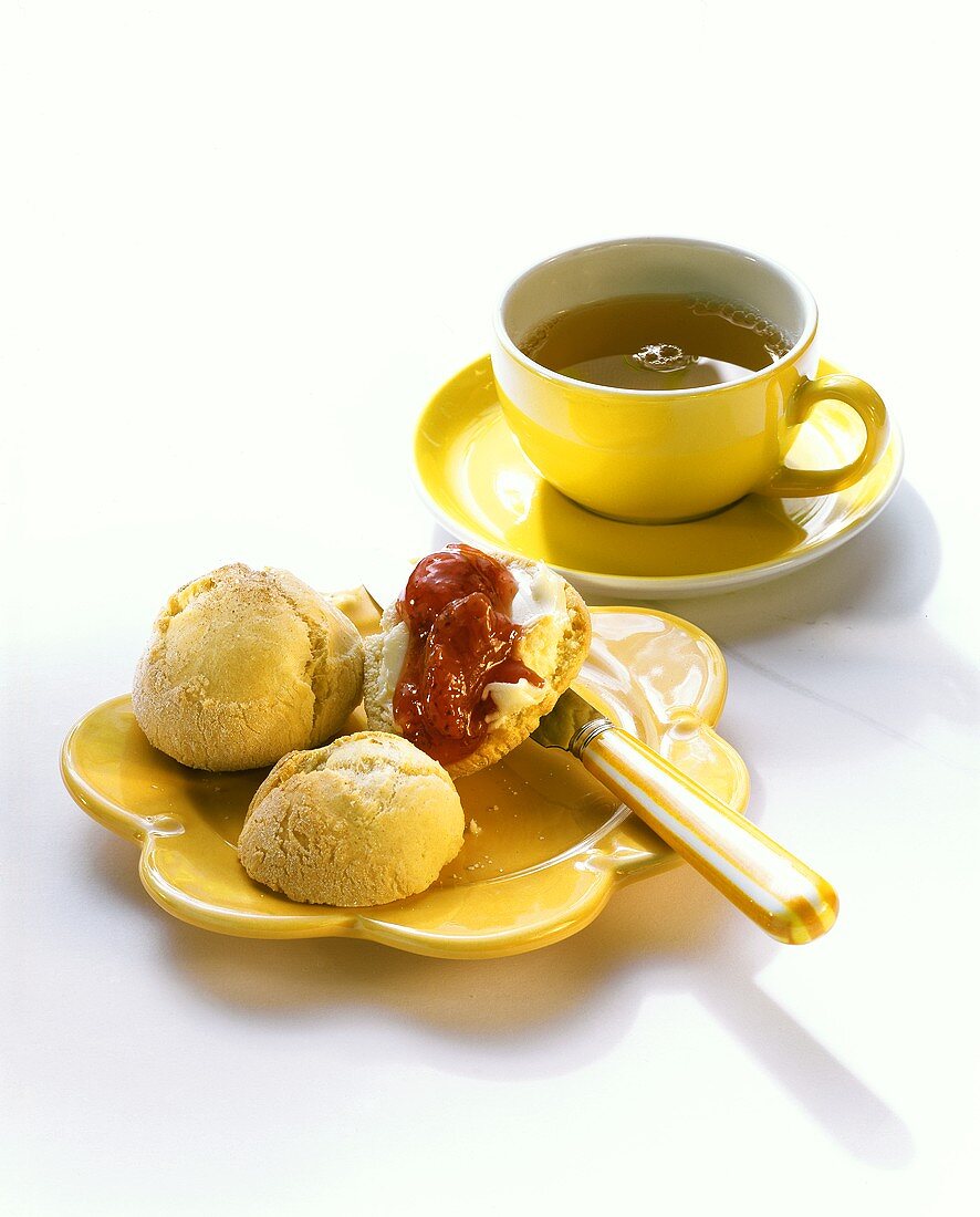 Teebrötchen mit Marmelade und Tasse Tee