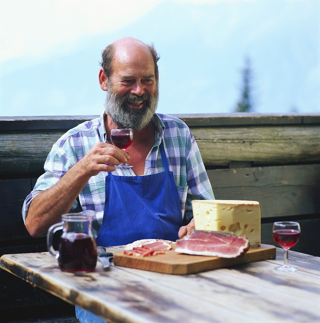 Farmer having afternoon snack (Jause) with bacon, cheese & wine