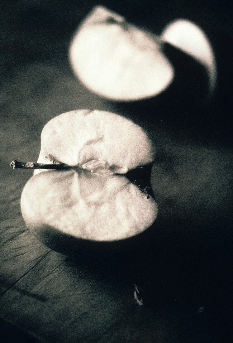 Halved apple on wooden surface