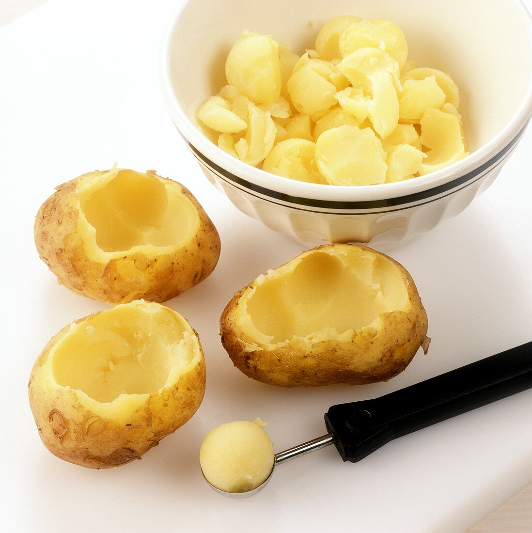 Hollowing out jacket potatoes before stuffing