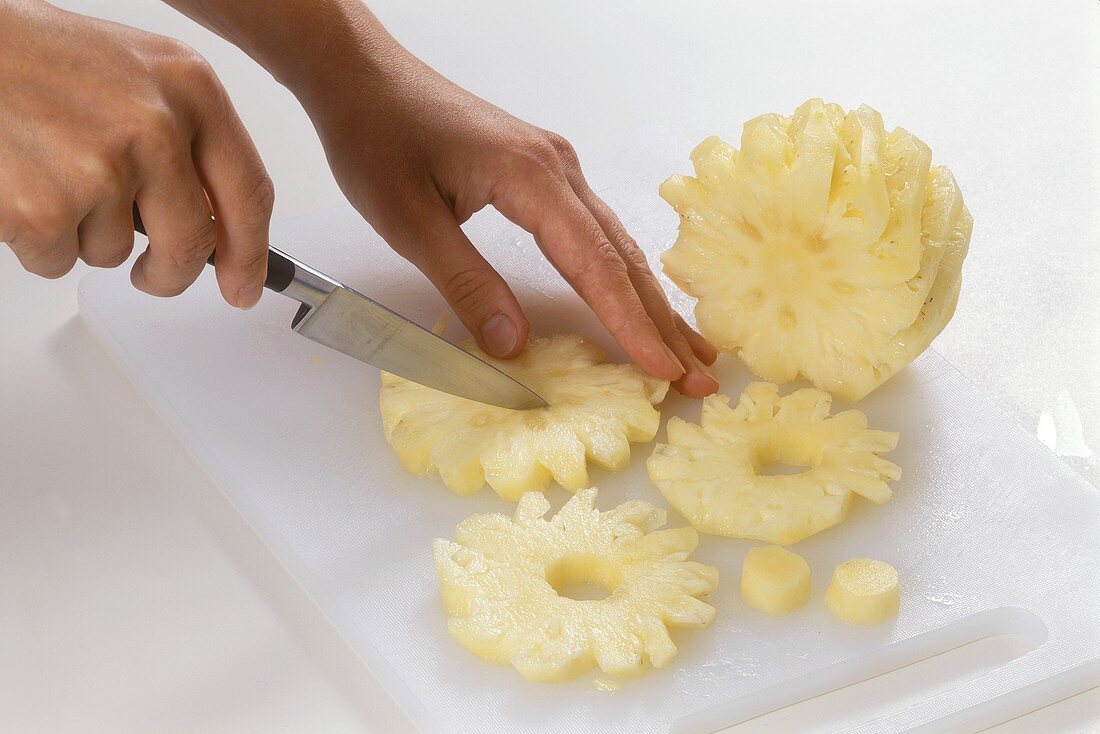 Removing the stalk from pineapple slices