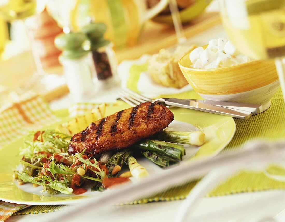 Grilled pork escalope with salad and vegetables on plate