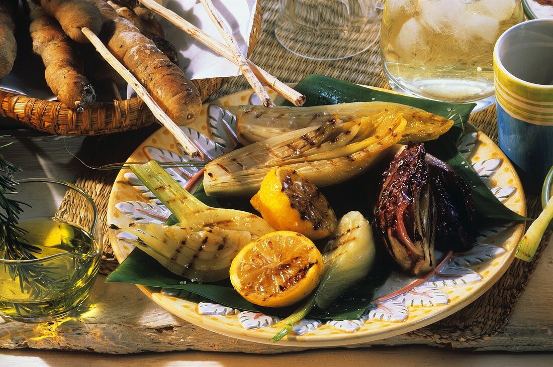 Grilled vegetables and oranges, with bread stick