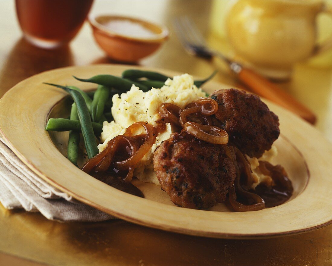 Rissoles with mashed potato, beans and onion sauce