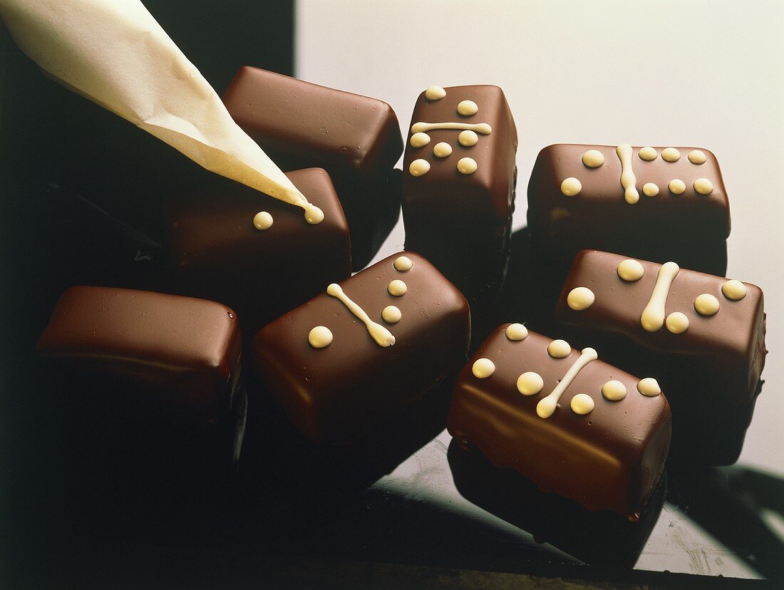 Dominosteine werden mit weisser Schokolade verziert