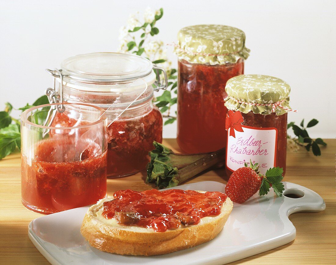 Strawberry and rhubarb preserve in jars and on roll