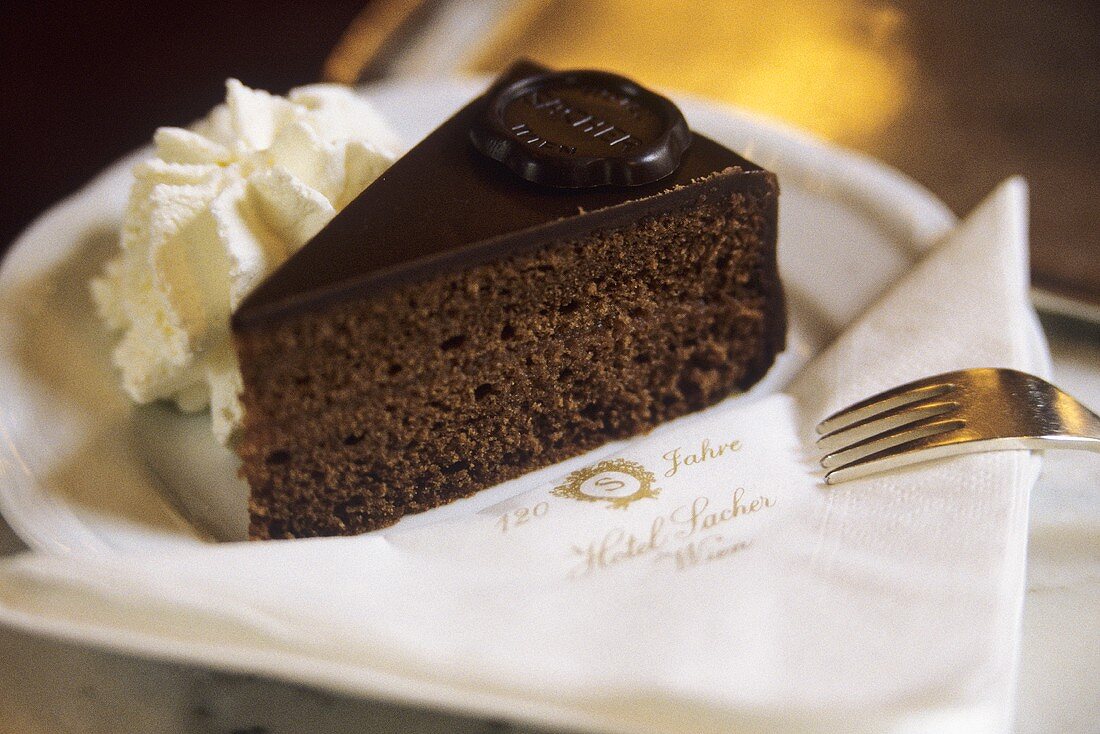 Ein Stück Sachertorte mit Sahne im Hotel Sacher in Wien