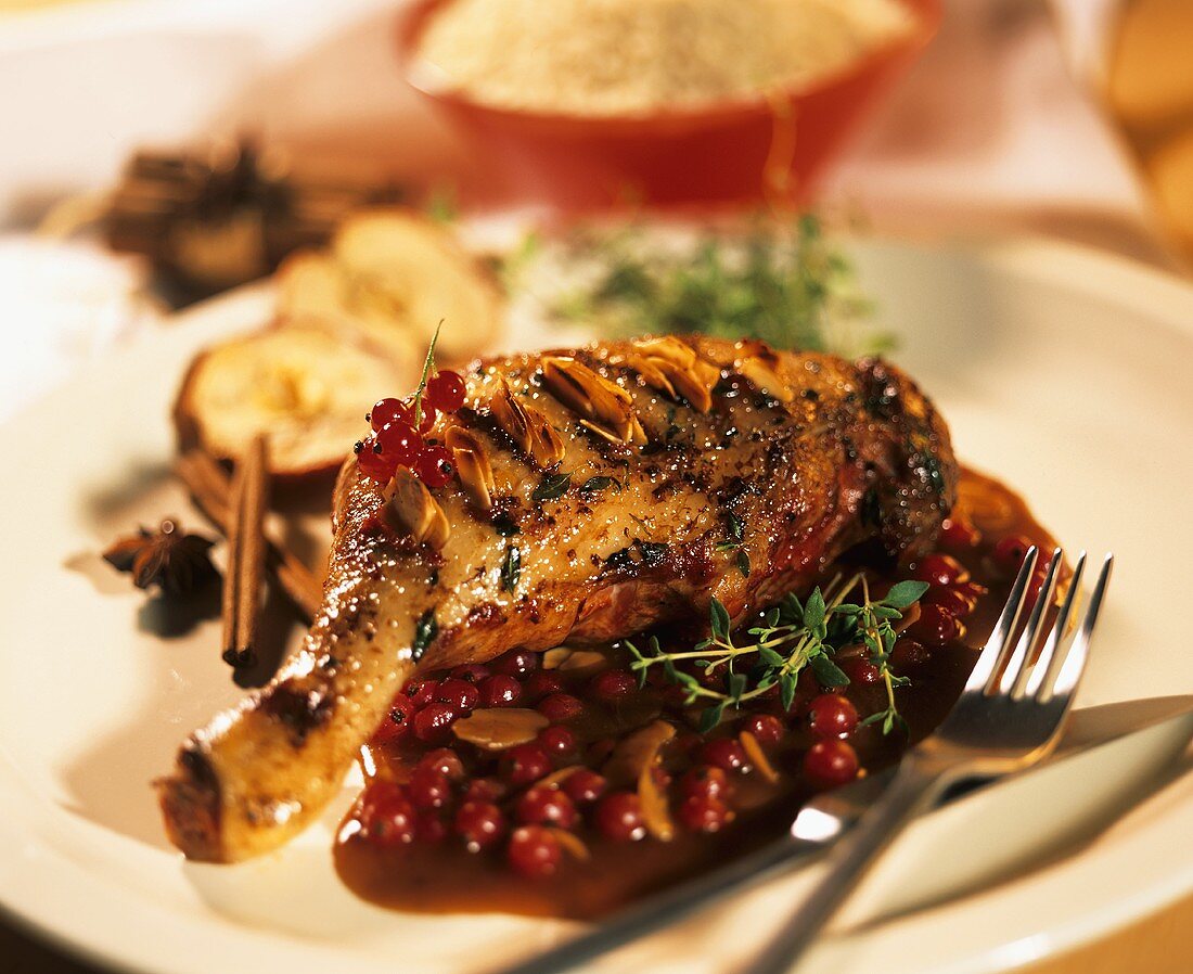 Duck leg with redcurrant sauce and almond flakes