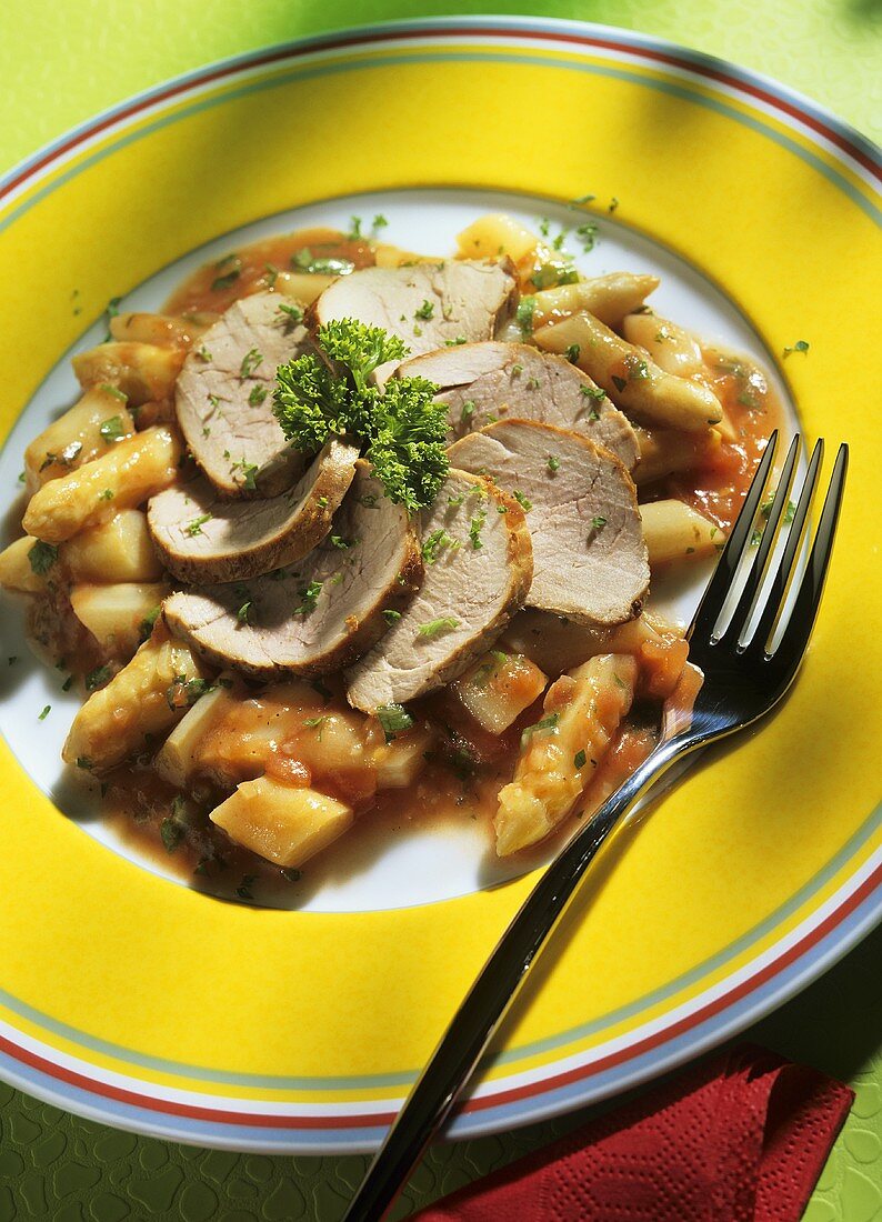 Pork fillet on asparagus and tomatoes