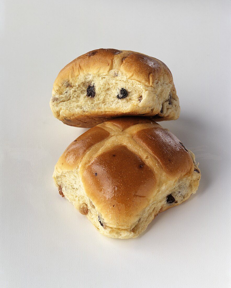Two hot cross buns against white background
