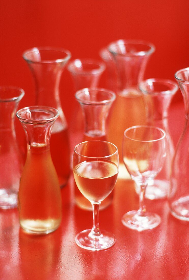Weißwein in mehreren Karaffen und im Glas