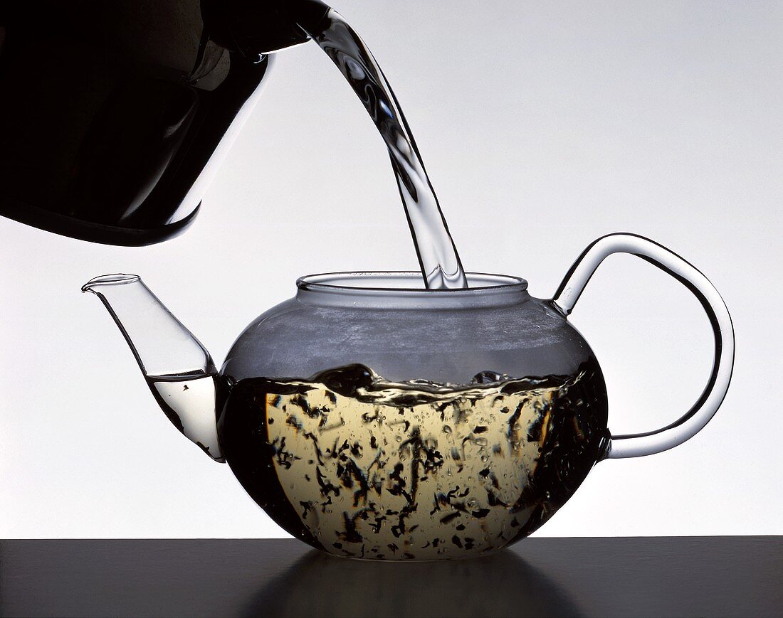 Das kochende Wasser über die Teeblätter gießen