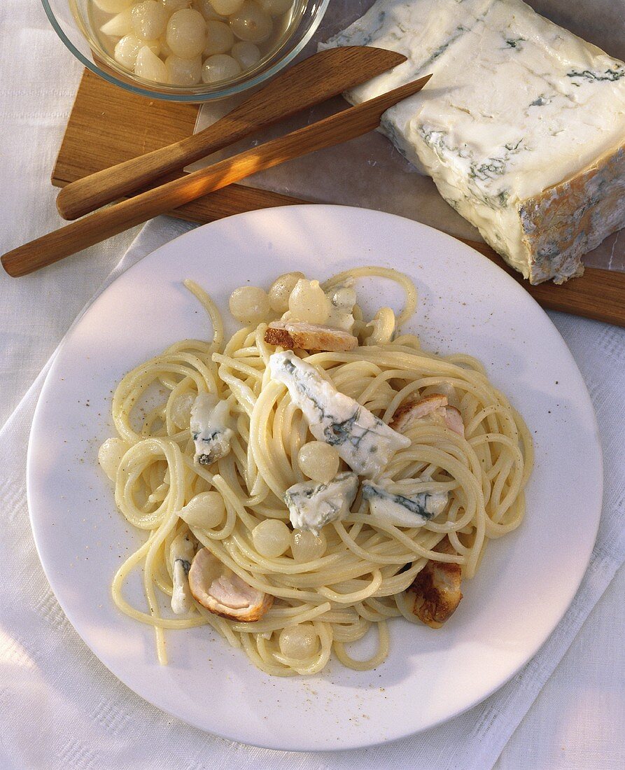 Spaghetti with pearl onions, turkey roll and gorgonzola