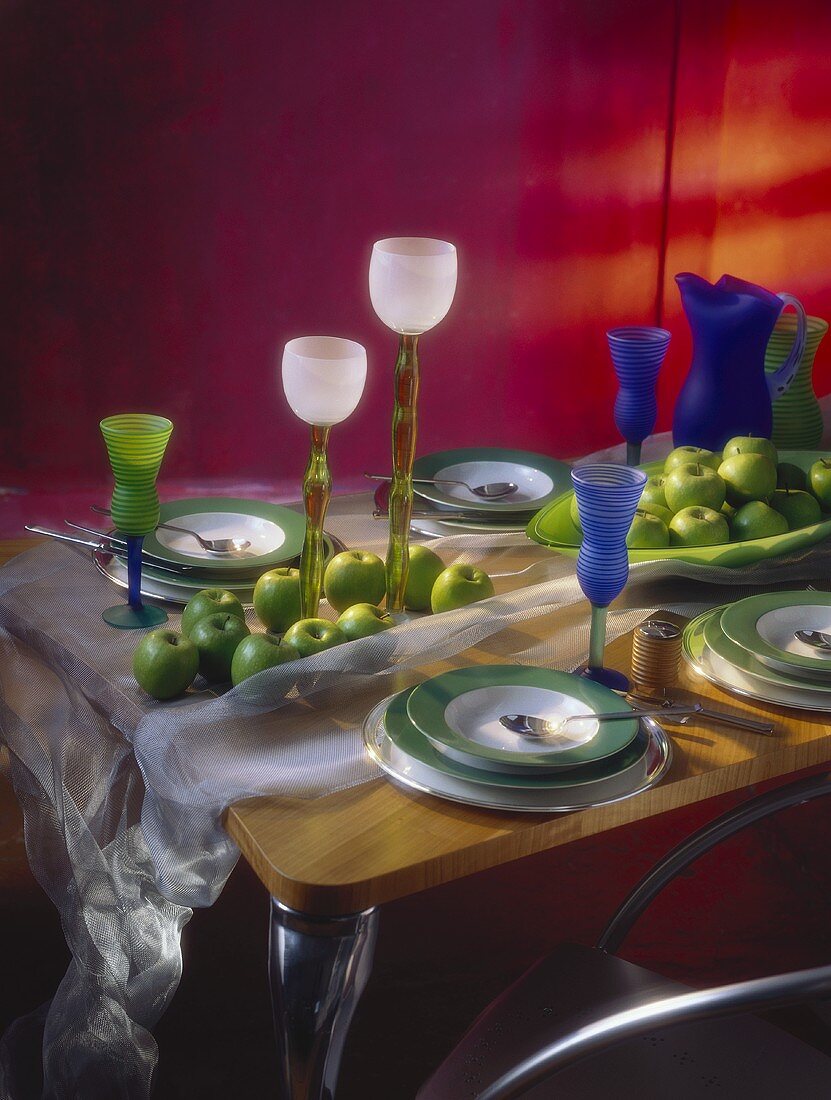 Gedeckter Tisch, dekoriert mit grünen Äpfeln