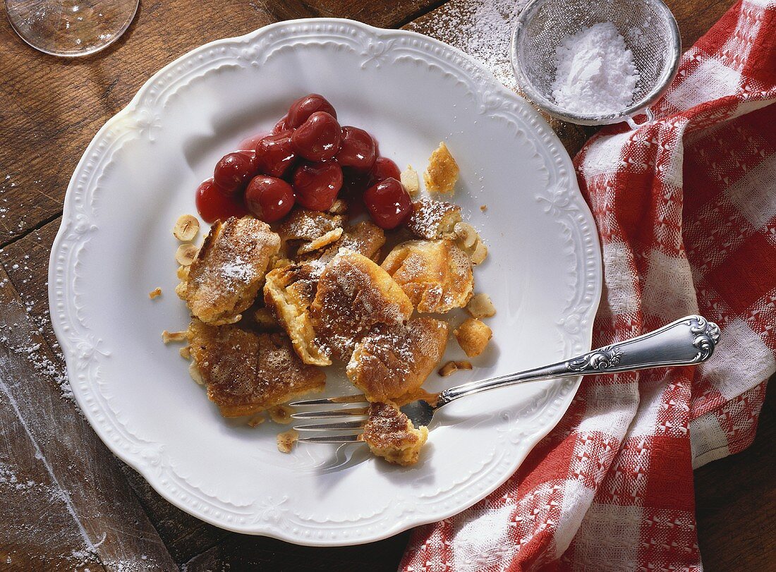 Sour cream and nut pancake with cherries on plate