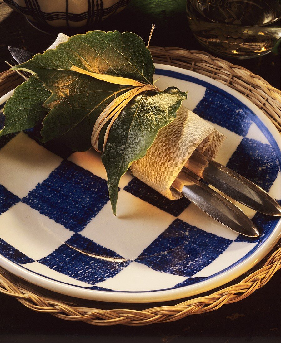 Cutlery rolled in napkin with vine leaves