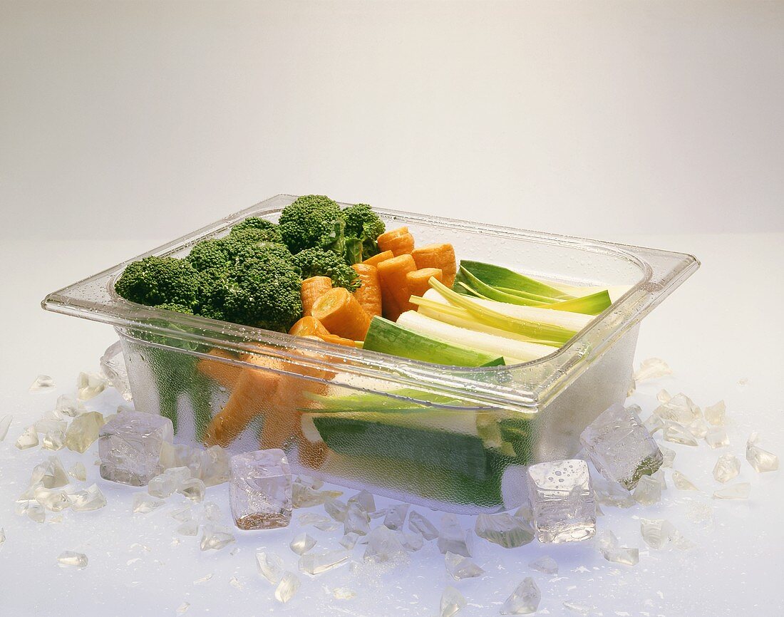 Gefrorenes Gemüse in Behälter mit Eis