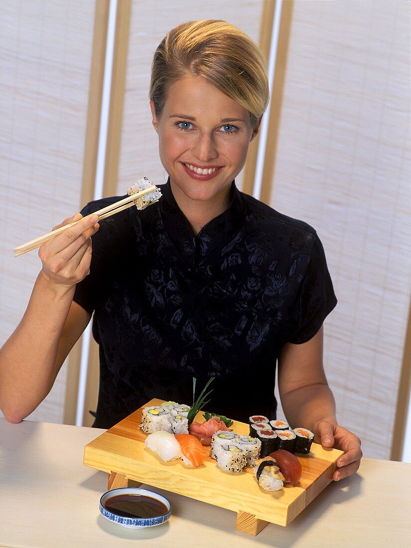 A Woman Eating Sushi with Chopsticks