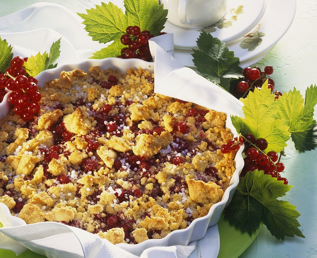 Redcurrant crumble cake with almonds in baking tin