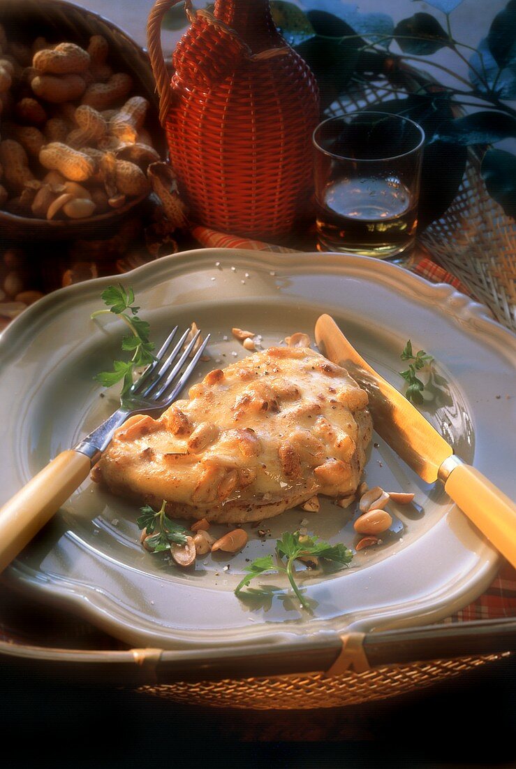 Schweineschnitzel mit Erdnuss-Käse-Kruste auf Teller