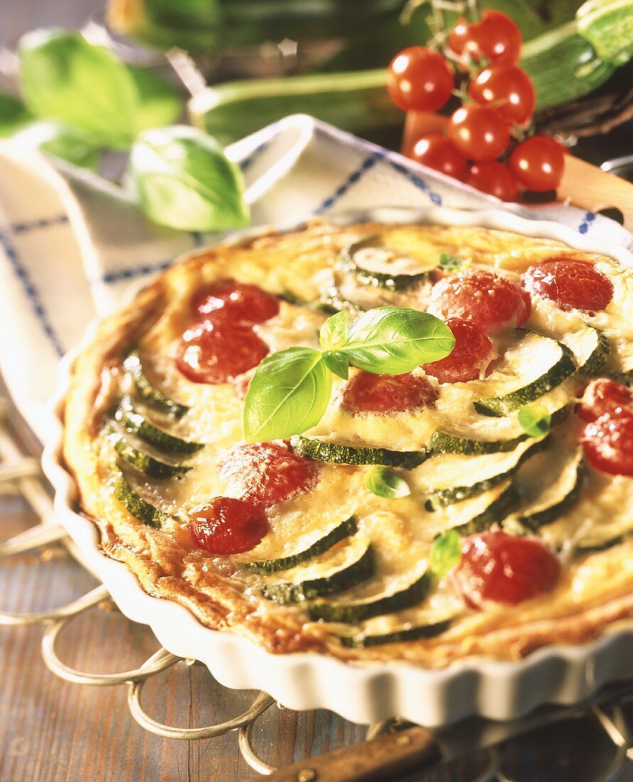 Courgette and tomato quiche garnished with basil