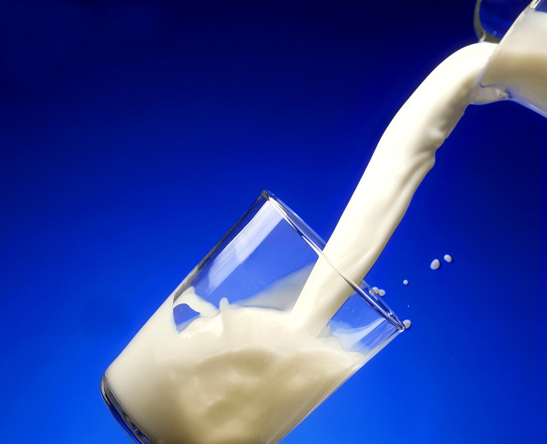 Milch wird in ein Glas gegossen